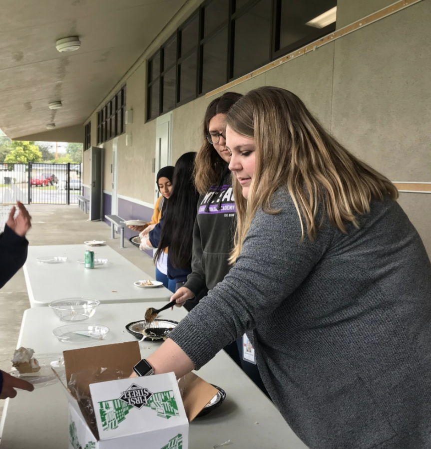 Ms. Sprague and Angelina Martinez pass out pie to people who have participated in the Pi Day challenge.