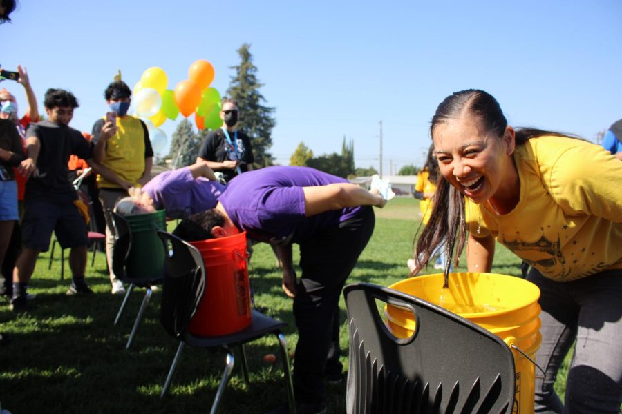 Ms. Yao cant help but laugh as she tries to get the apple out of the bucket before Mr. Janadi, Ms. Wilcox and Mr. Nichols. 