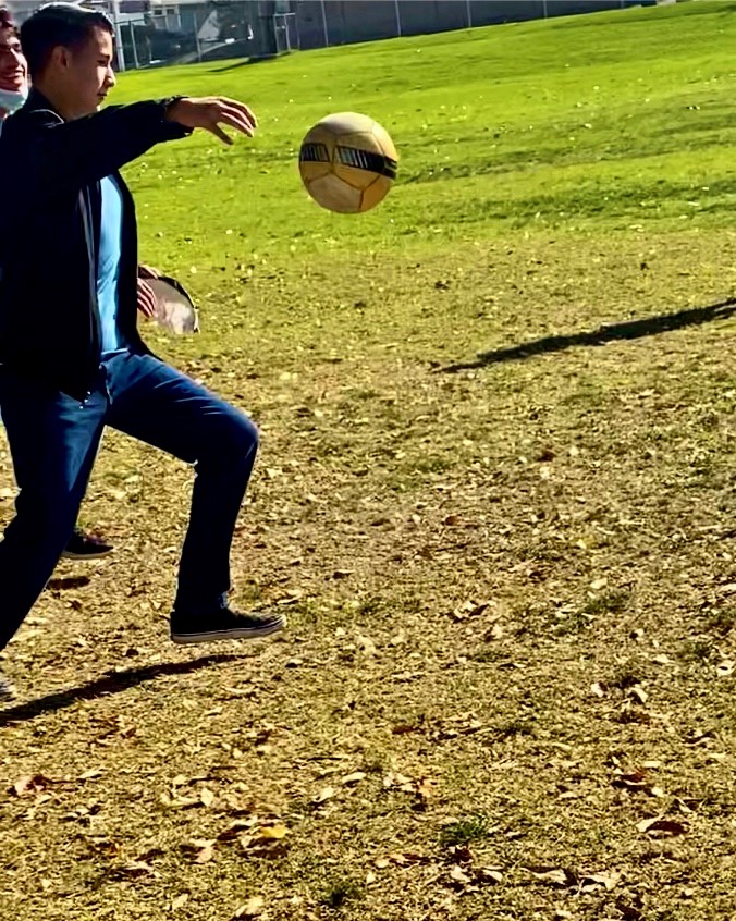 Gabe Metzgar drop kicking the soccer ball