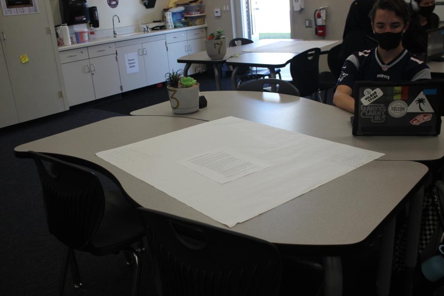 Freshman Jackson Barrett works alone as his table and surrounding table are mostly empty due to absences.