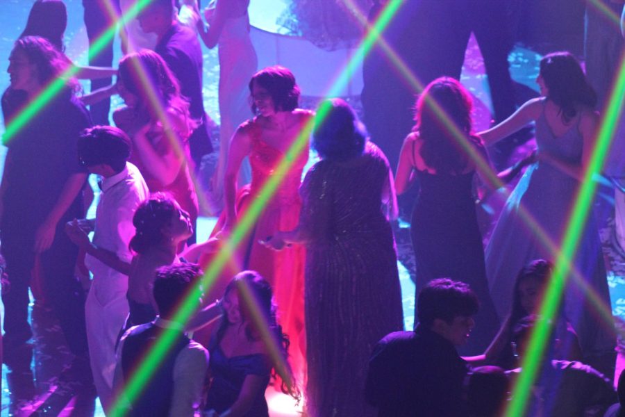 Daniela Arreola and Emely Estrada dance together, surrounded by other dancing pairs. 