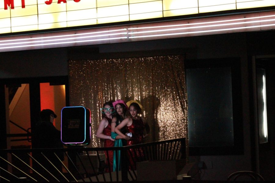 Katelyn Cherry, Anisa Oza, and Payton Zarceno take pictures at a photo booth. 