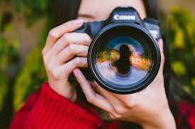 Woman taking a photo. (Photo by Wallpaper Flare)