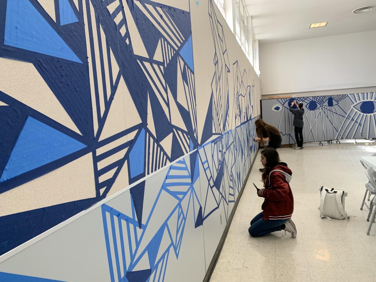 Art students create tape murals in the MPR as part of the Art 2 curriculum in Elizabeth Hoffmans class.