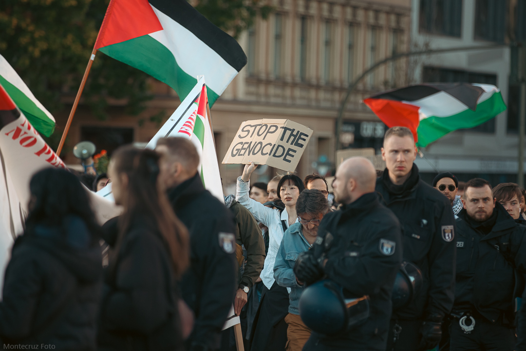 Demonstrators in Oranienplatz Square, Berlin, Germany, protesting against the ongoing genocide in Palestine. Photo credits: Wikimedia Commons