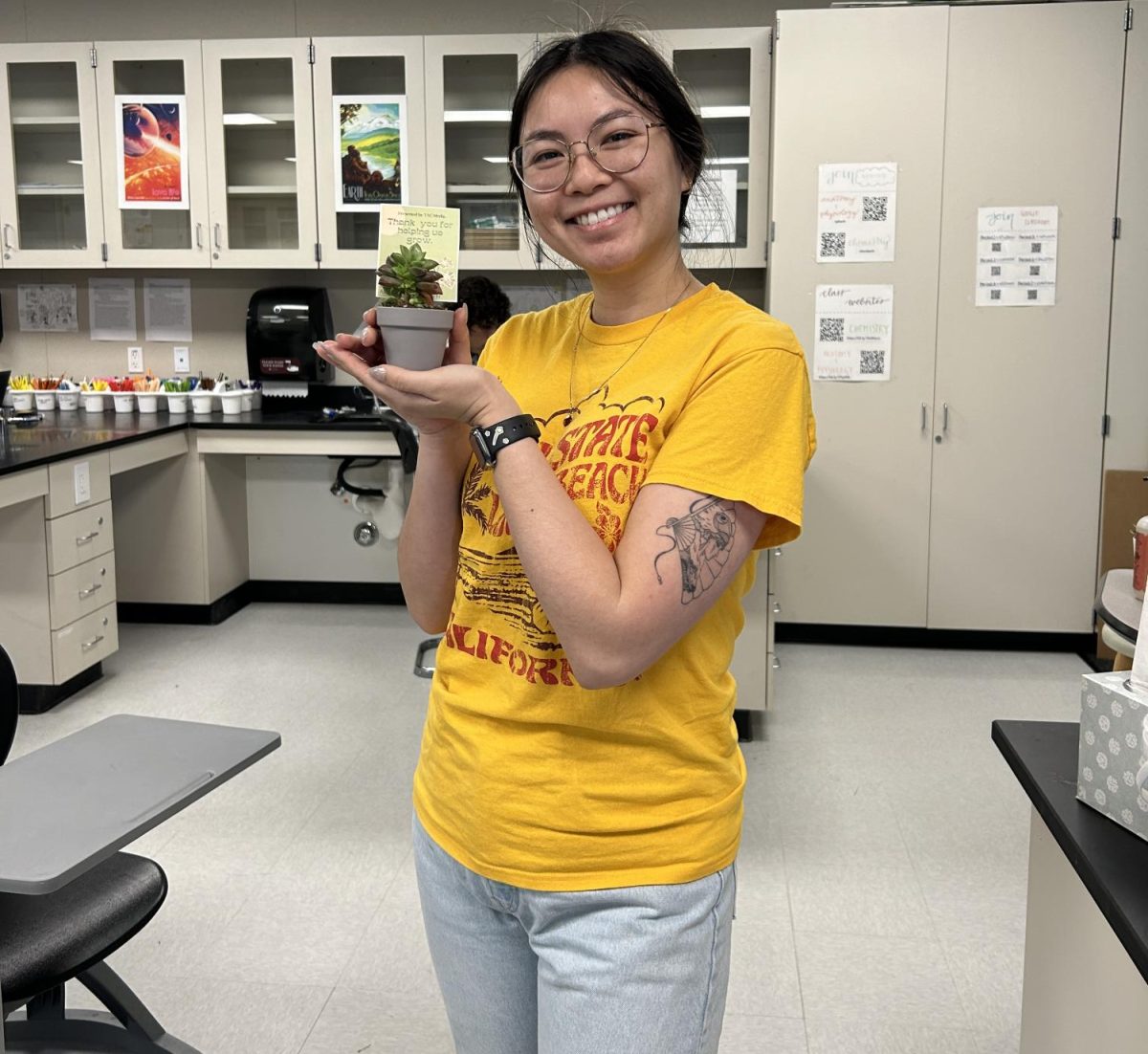 Chemistry and Anatomy and Physiology Teacher Tiffany Banh, poses with her plant; Ms. Banh makes chemistry fun with activities like learning about the chemistry behind farting! 