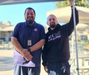 Security Guard Alex Palacios and custodian Joshua Del Real smiling wide after setting up the easy-up for the lunch line. 
