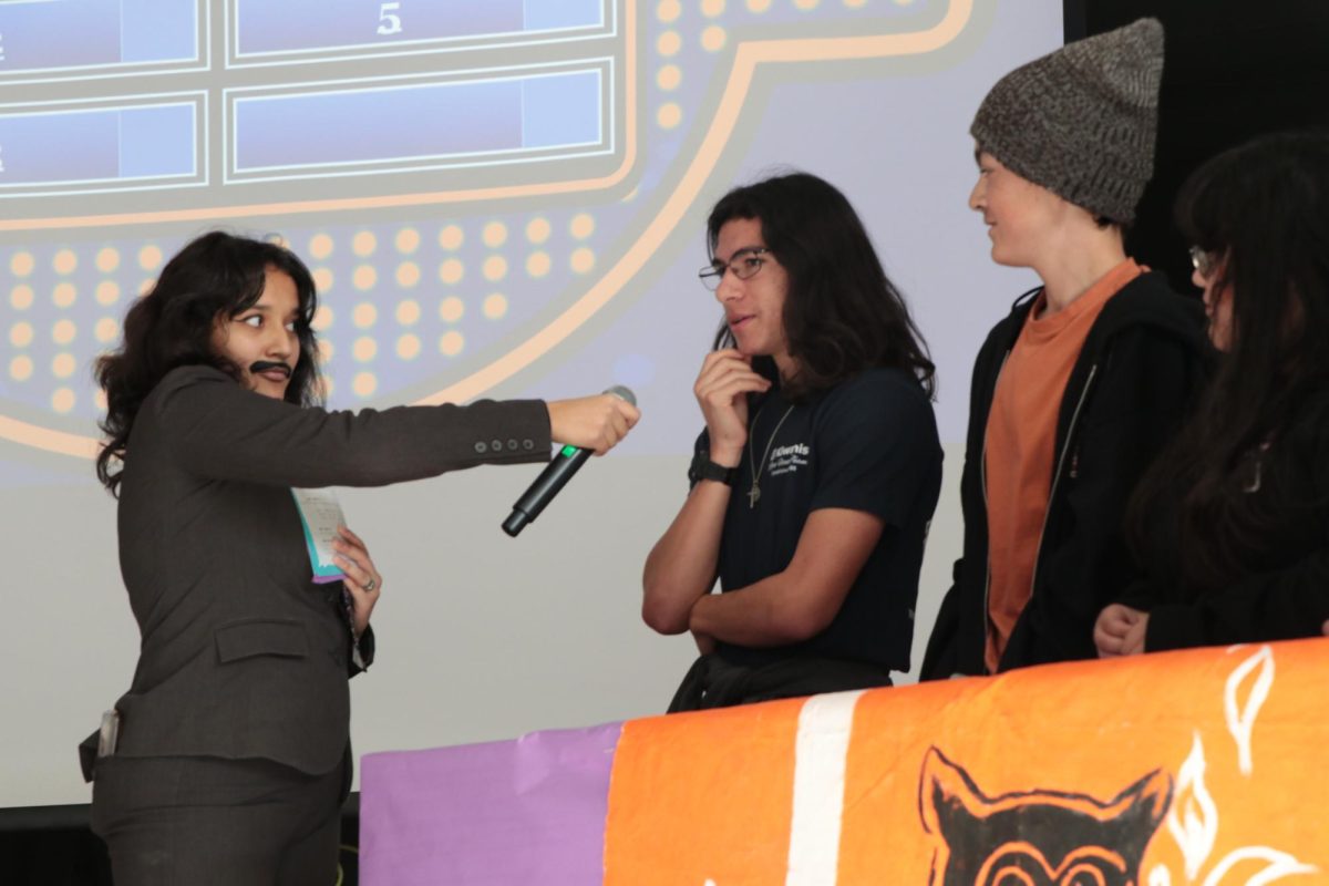 Dressed up as Steve Harvey for the House Competition, Amalie Esparza (12) asks Gamma House members' Daulton Lista (12) and Jared Jimenez (10) Family Feud style questions.