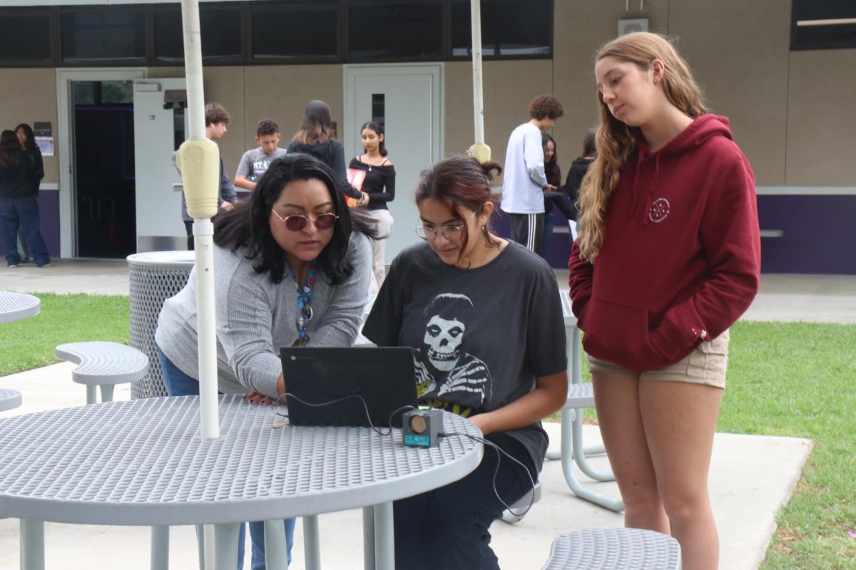 Crystal Guevara assists Math 1 students Savannah Banuelos (10) and Gemma Alvarez-Resley (10) in a Motion Detector Activity.