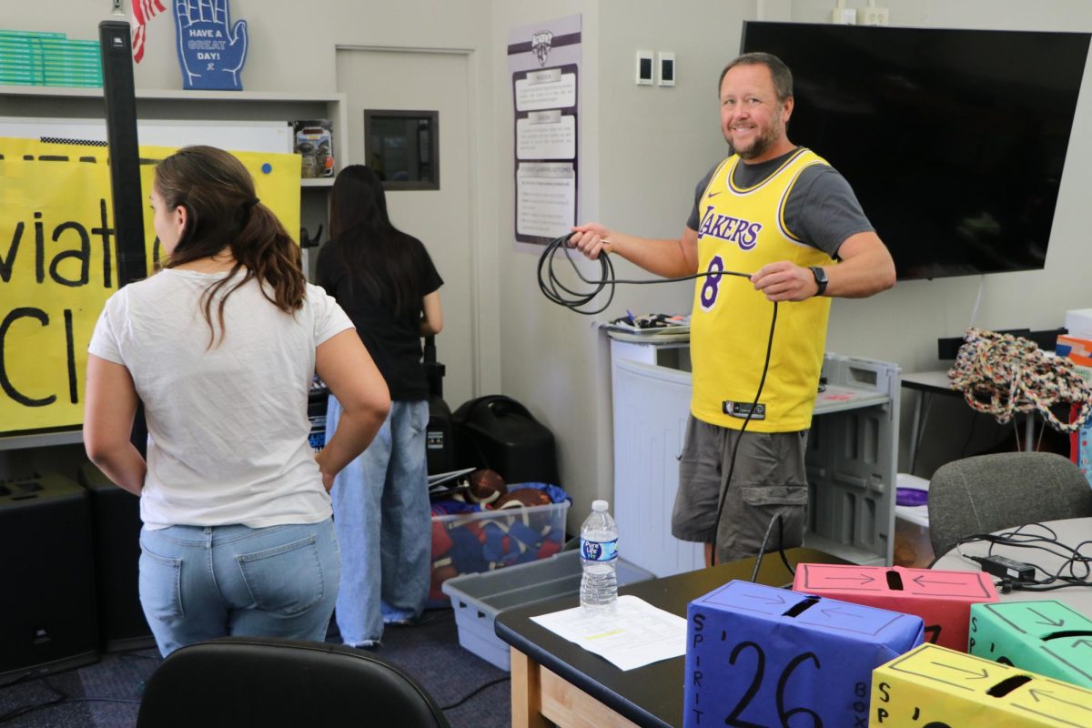 ASB advisor Gabriel Nichols helping ASB prepare decorations for the week in the new ASB room.
