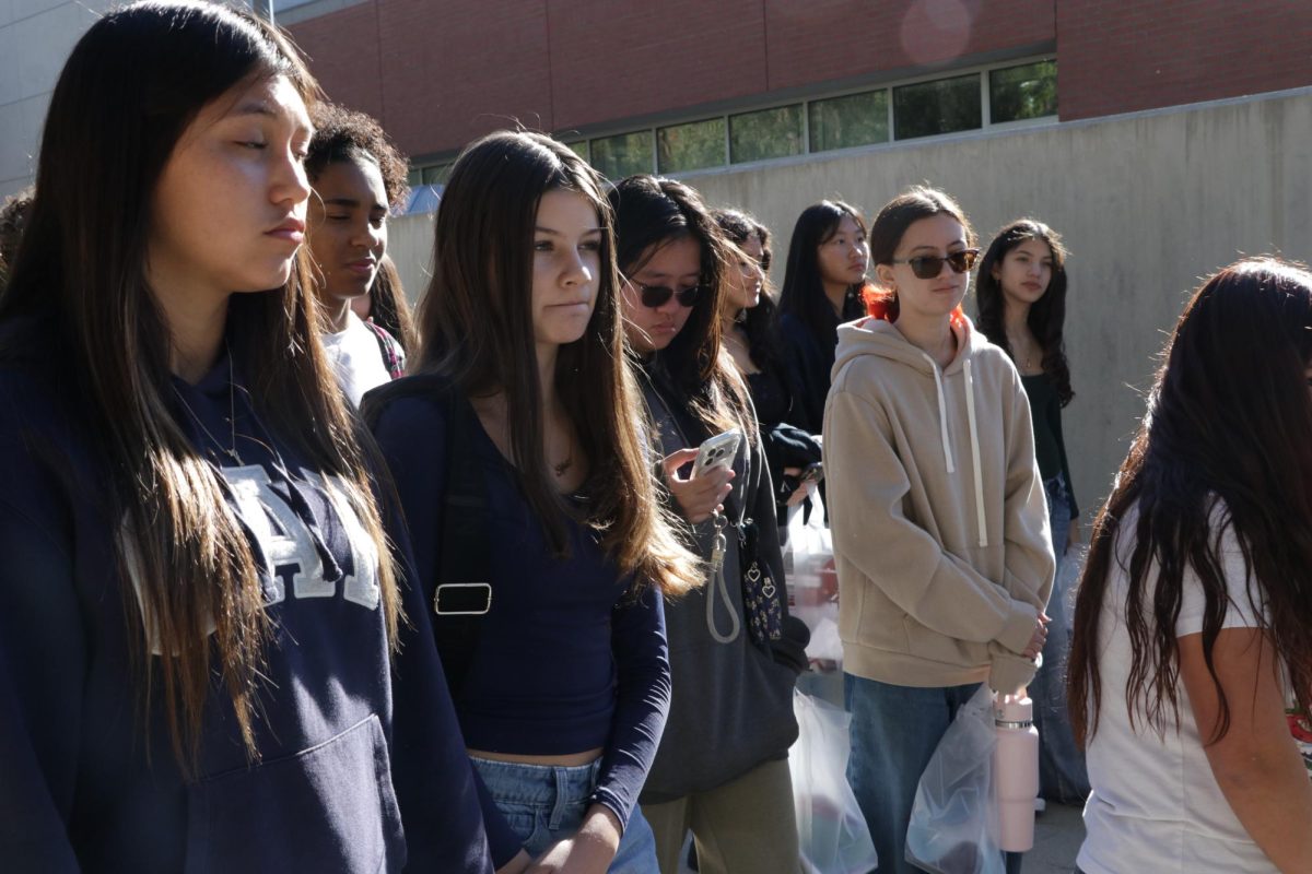 Listening pensively, Sophia Gomez Morando (9), Cassia Fung  (9), Adelina Kenworthy (9), and Natalia Mora (9) give their full attention to the campus tour guide. The tour guide explains programs that may be of interest to the group of students.