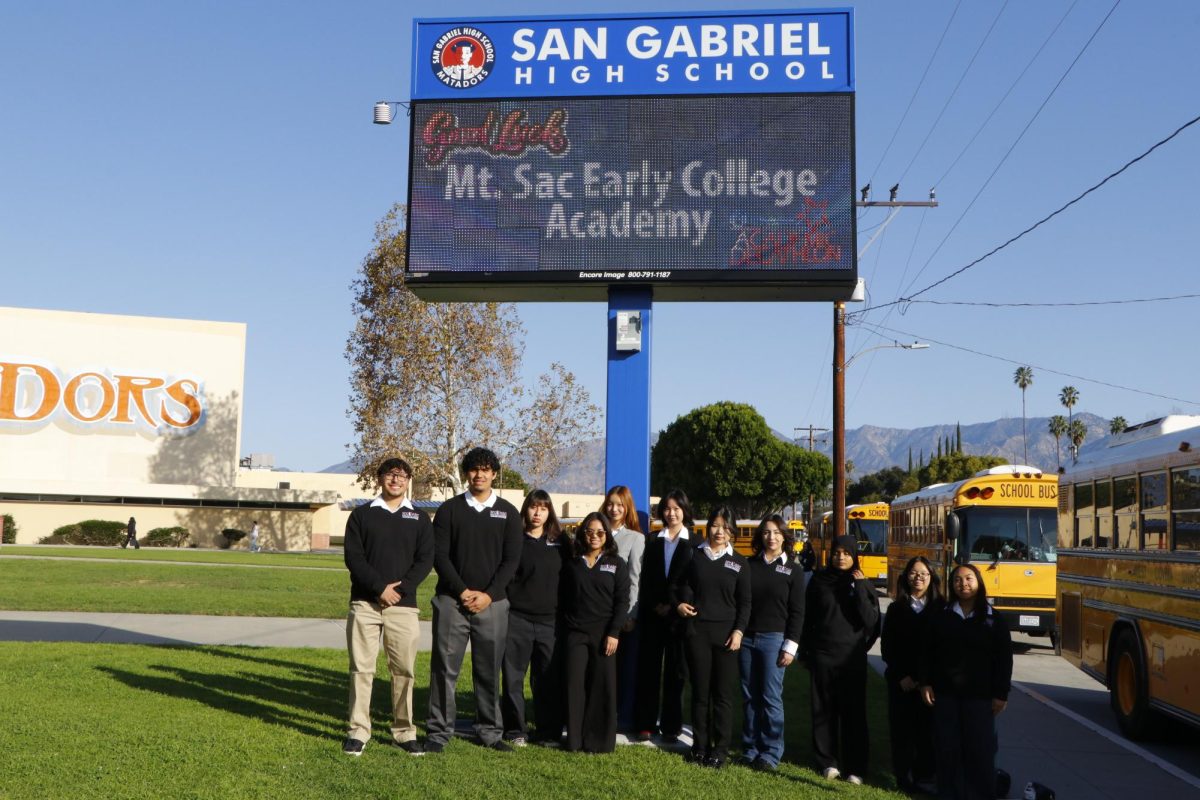 Anthony Reyes (12), Tepotchli Cervantes (12), Dulce Chacon (12), Thearose Garcia (12), Katelyn Chung (11), Karren Zhuang (11), Mckenna Chung (10), Genevieve Hijar (11), Hazel Shafiq (11), Jocelyn Lee (11), and Michelle Calinisan (11) pose for a group photo in front of San Gabriel High School. 