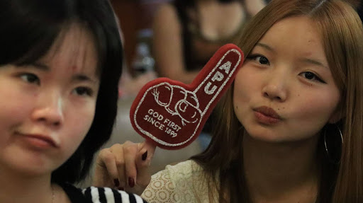 Juniors Karren Zhuang and Katelyn Chung enjoy the free APU merch.