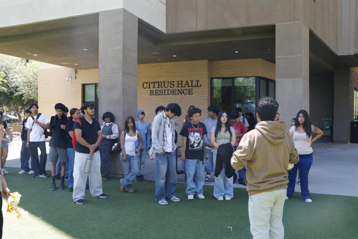One of the two groups that toured ULV listen to their tour guide as he explains the in campus stores. The group, at the center of the campus, are told about the university's cafeteria, cook story, and gym.